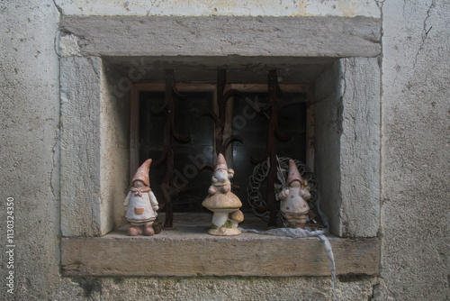 Dettaglio della finestra di una casa di Colcerver, borgo della Val di Zoldo nelle Dolomiti bellunesi, con tre statuine di gnomi photo