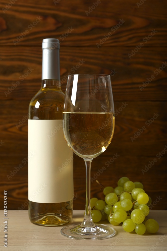 Fototapeta premium Bottle of white wine with grapes, glass, corkscrew and corks on wooden background
