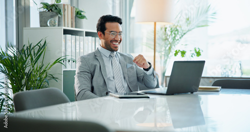 Happy, businessman and laptop with winning for good news, financial profit or online credit report. Asian man, accountant or finance with smile on computer for salary increase or return on investment photo