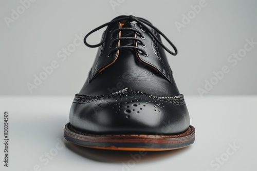 A black leather shoe with a sleek cap toe, crafted for sophistication and ideal for professional settings on a plain white background. photo