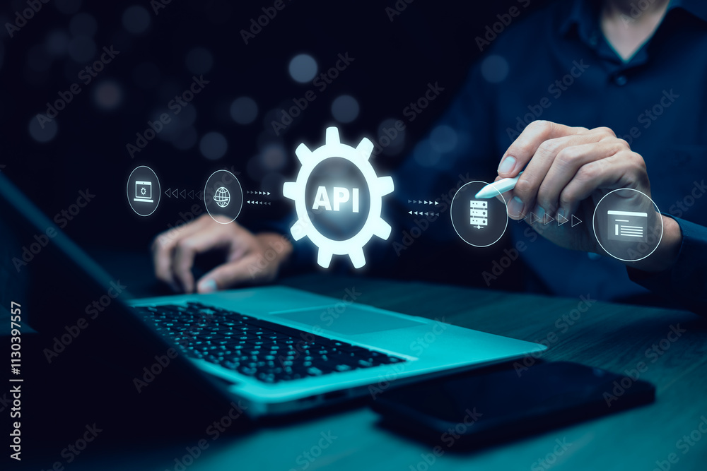 © Bussarin - Businessman using laptop with API  icon on a virtual screen in the background of technology device internet, API Application Programming Interface connects services on the internet data communication.