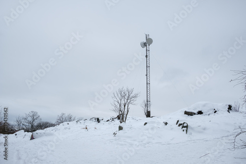 Winter landscape in Stockholm with snow-covered terrain and a communication tower