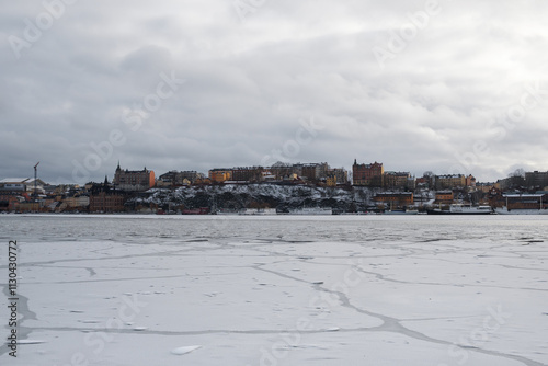 Snowy landscape of Stockholm with frozen water and colorful buildings in winter