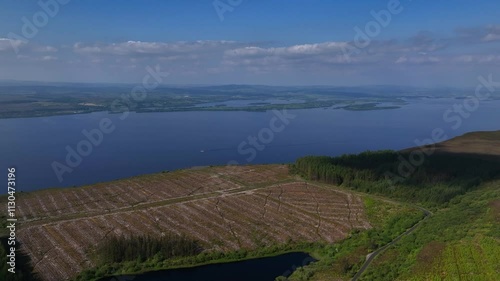 Cliffs of Magho Viewpoint, Lower Lough Erne, County Fermanagh, Northern Ireland, June 2023. Drone orbits counter clockwise and descends above the cleared forest with the beautiful lake in the distance photo