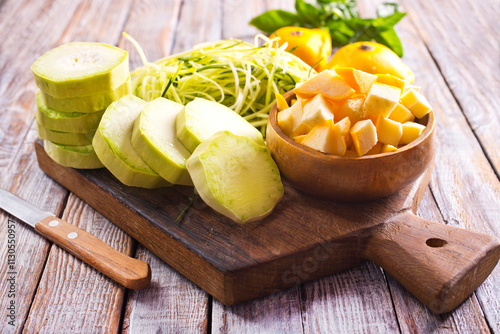 raw zucchini and patisons on board on a table photo