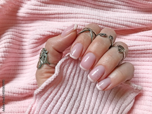 Female Hand French Manicure Gradient Nails Pink-White Coloring on Pink Knitted Textile Background photo