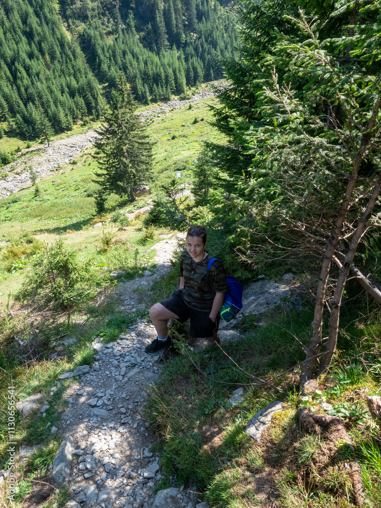 Fototapeta premium Tourists on the way to the rock cell of Priest Arsenie Boca, Fagaras mountains, Romania