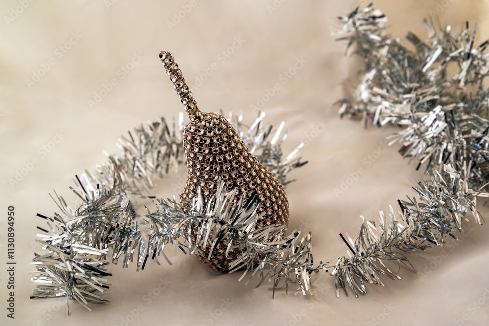 Obraz premium Decorative golden metallic pear and silver Christmas chain.