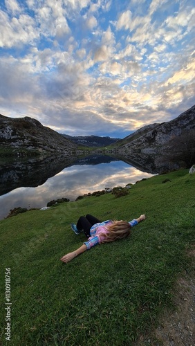 person on the mountain in front of lake