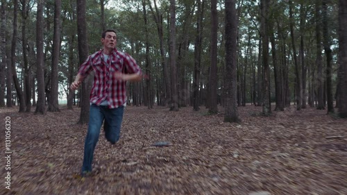 Fearful man running away from something in dark forest