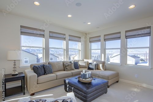 Living room with a tan couch and a black ottoman