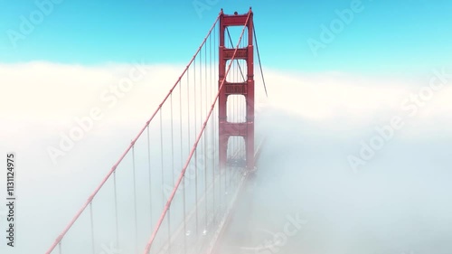 Rising, aerial drone video passing a support of the fog shrouded Golden Gate Bridge in San Francisco, Ca.