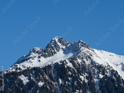 rocher des enclaves dans le beaufortain, en hiver et ciel bleu avec neige