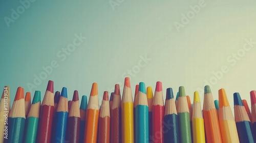 Colorful pencils aligned against gradient background. Creativity and art