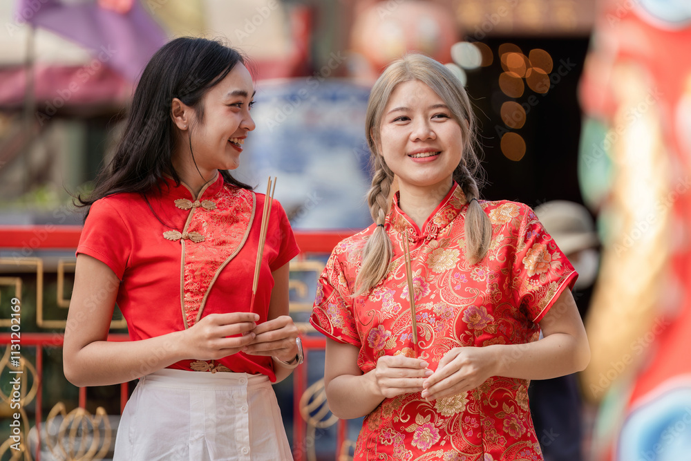 Obraz premium Celebrating chinese new year joyful friends in traditional attire festive street colorful environment candid viewpoint cultural significance