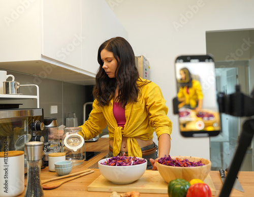 Young woman is broadcasting live from workshop how to prepare a vegetarian food