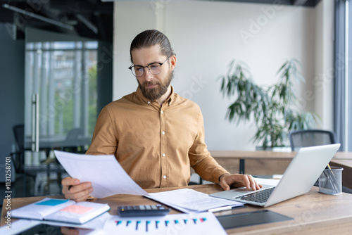 Focused professional reviewing important paperwork at their desk in a contemporary office setting. Effective workplace organization tools and technology enhance the atmosphere of productivity photo