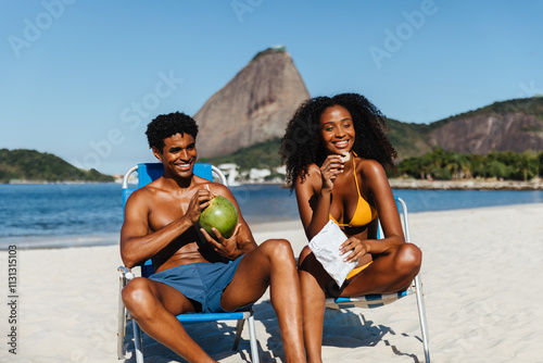 Happy couple enjoying a sunny day at Praia do Flamengo beach with Sugarloaf Mountain in the background photo