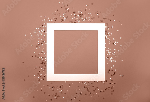 Demonstrating color of the year 2025. Mocha mousse color swatch. Empty frame square paper card and holographic glitter shining stars confetti flat lay on sepia background