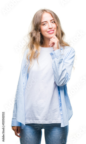 Beautiful young blonde woman over isolated background looking confident at the camera with smile with crossed arms and hand raised on chin. Thinking positive.