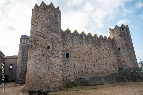 Calonge Castle with towers and walls under a cloudy sky photo