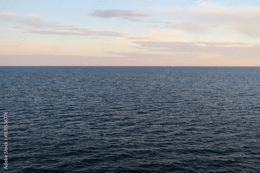 Fototapeta premium Über dem Skagerrak geht an diesem Sommerabend die Sonne langsam unter. Über dem Horizont ist bereits das beginnende Abendrot vom Sonnendeck einer Fähre von Oslo nach Kopenhagen zu sehen.
