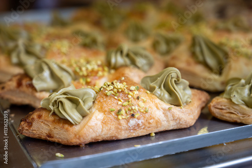 Homemade sweet pastry cannolo sfoglie filled with almond, pistachio, lemon, vanilla, chocolate cream on food market in Italy photo