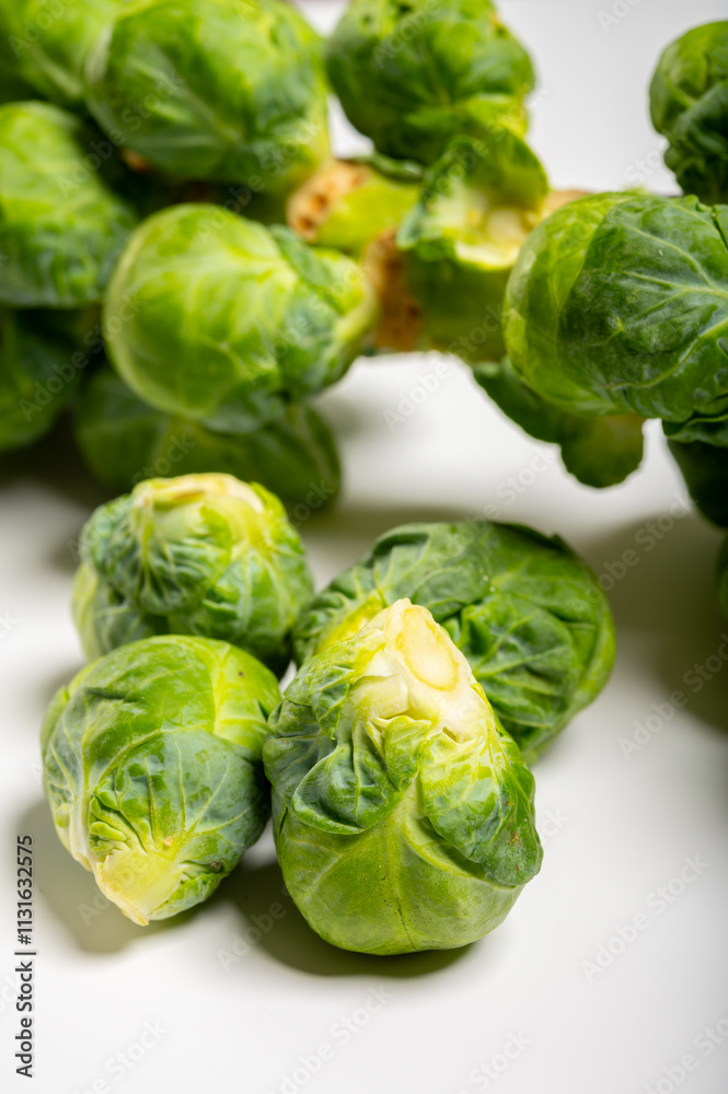 Fototapeta premium Green brussels sprouts on stalks on white table