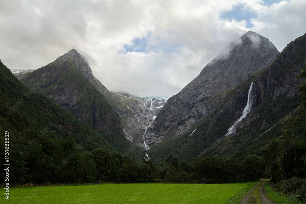 Obraz premium Jostedalsbreen Glacier stands majestically, with its vast icy expanse surrounded by towering, snow-capped mountains.