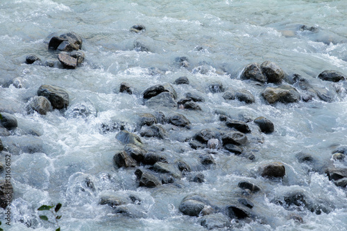 A powerful glacier river flows from the Jostedalsbreen Glacier, cutting through the rugged landscape. The river’s milky turquoise waters, fed by glacial melt photo