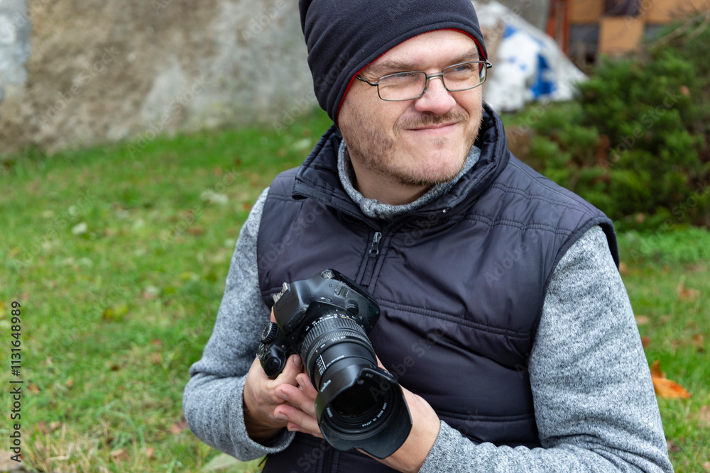 A man with a camera walking through an autumn city.