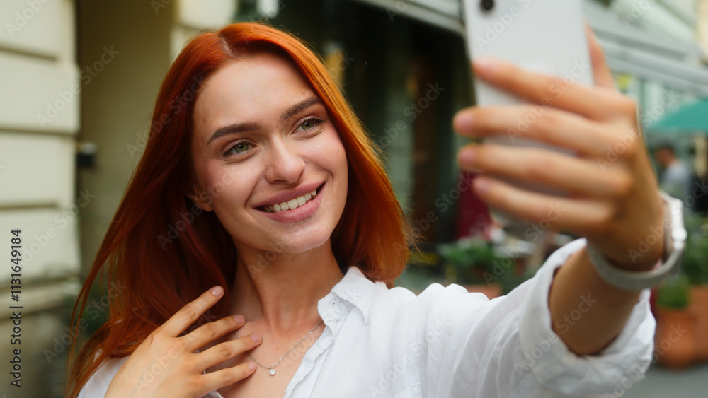 Fototapeta premium Caucasian woman female model girl tourist traveler blogger vlogger influencer beautiful lady happy smiling in city selfie photo mobile phone camera posing social media video blog vlog outdoors street