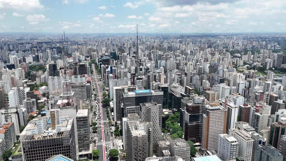 Visão aérea da Avenida Paulista, em São Paulo, Brasil, destacando o movimentado centro da cidade, os edifícios modernos e a arquitetura icônica, com vista panorâmica da principal via paulistana
