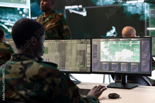 Army IT specialist interprets registered satellite CCTV footage for insight while he is targeting enemy positions. Air force crew officer takes notes about hostile vessels trajectory, reconnaissance.
