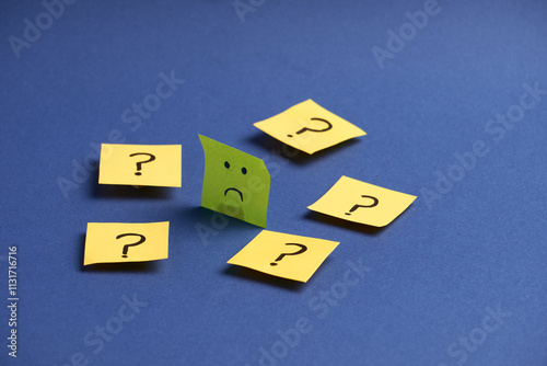 Fotografie Sad face surrounded by question marks represents inner doubts, emotional dilemmas, and decision-making confusion