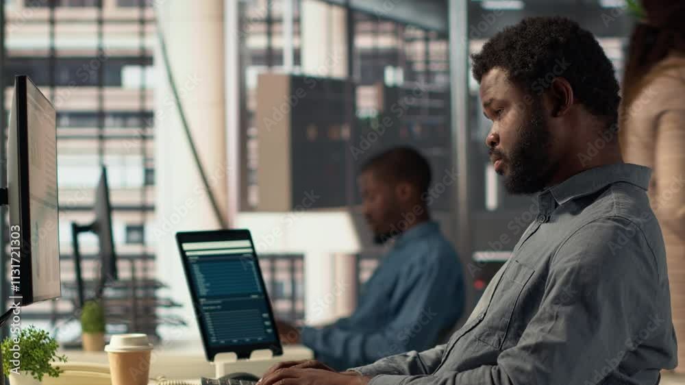 Male executive analyst finalizes a financial report and reviews data, developing a forecast for organizational progress. Black man engaged in task management and strategy planning. Camera A.