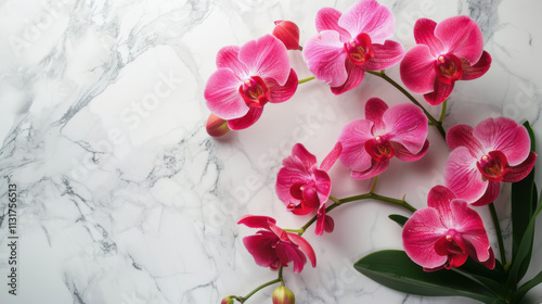 Artificial orchid plant in flower pot on white marble table. Space for text