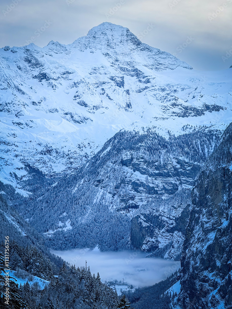 Scenic view of Lauterbrunnen Valley and Breithorn mountain, Switzerland seen from Wengen in winter against blue sky with clouds