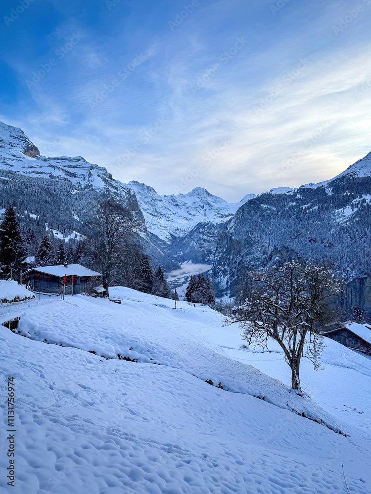 Scenic view of Lauterbrunnen Valley, Switzerland seen from Wengen with snowcovered Breithorn mountain in winter against blue sky with clouds