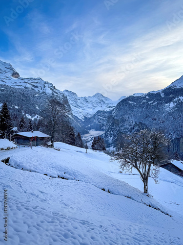 Obraz na płótnie Scenic view of Lauterbrunnen Valley, Switzerland seen from Wengen with snowcovered Breithorn mountain in winter against blue sky with clouds w salonie