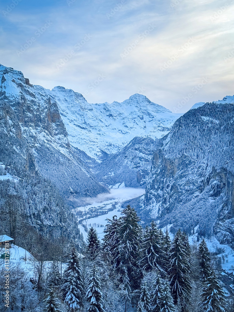 Scenic view of Lauterbrunnen Valley, Switzerland seen from Wengen with snowcovered Breithorn mountain in winter against blue sky with clouds
