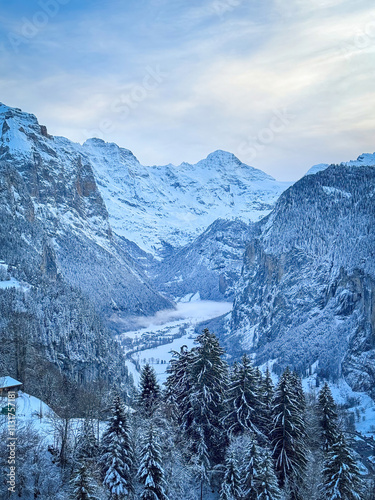 Obraz na płótnie Scenic view of Lauterbrunnen Valley, Switzerland seen from Wengen with snowcovered Breithorn mountain in winter against blue sky with clouds w salonie