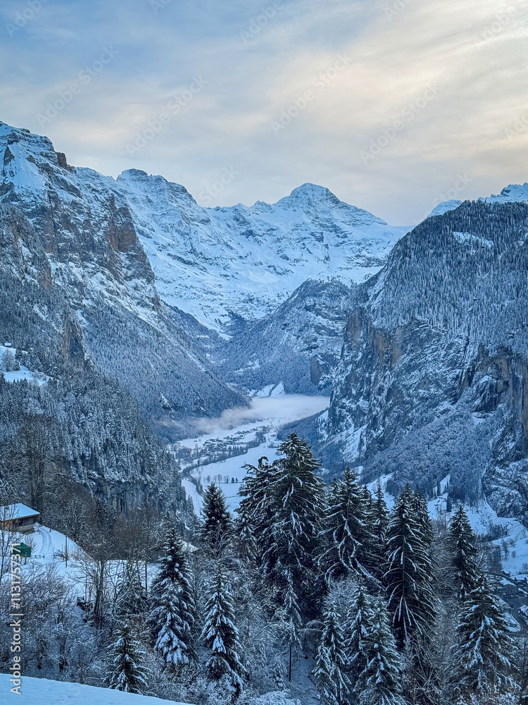 Scenic view of Lauterbrunnen Valley, Switzerland seen from Wengen with snowcovered Breithorn mountain in winter against blue sky with clouds
