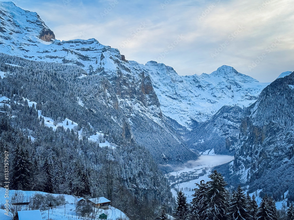 Scenic view of Lauterbrunnen Valley, Switzerland seen from Wengen with snowcovered Breithorn mountain in winter against blue sky with clouds