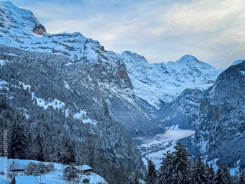 Obraz na płótnie Scenic view of Lauterbrunnen Valley, Switzerland seen from Wengen with snowcovered Breithorn mountain in winter against blue sky with clouds w salonie