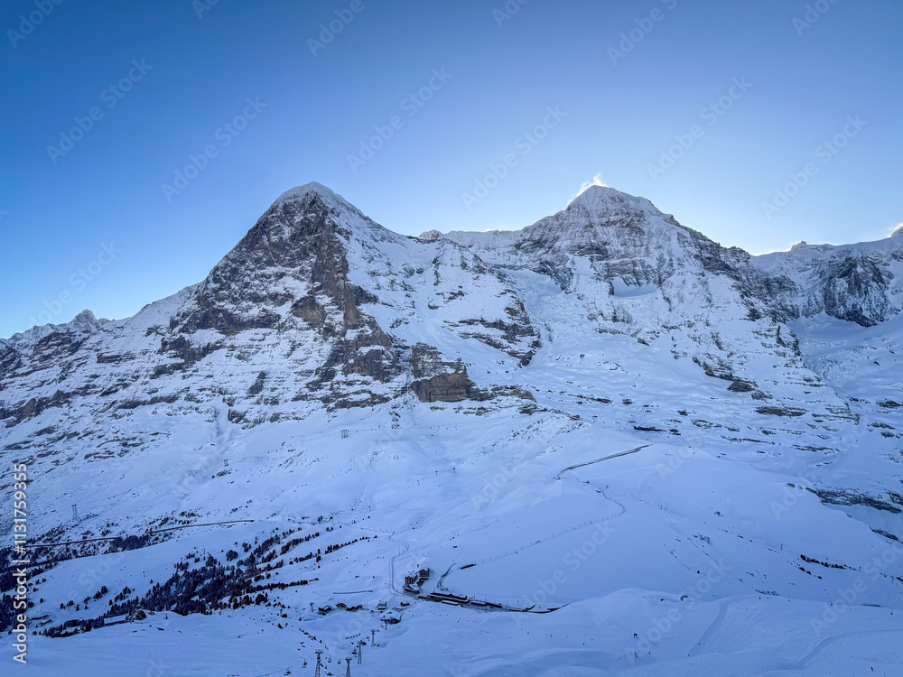 Scenic view of snowcovered Eiger and Moench mountains in Switzerland early in the morning against blue sky