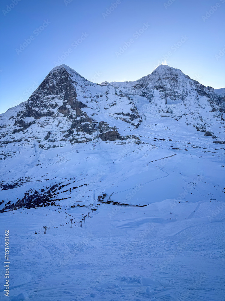 Scenic view of snowcovered Eiger and Moench mountains in Switzerland early in the morning against blue sky