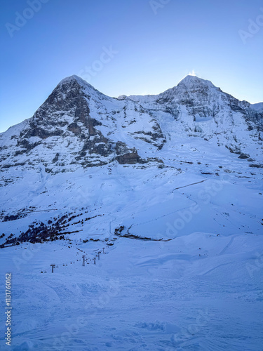 Obraz na płótnie Scenic view of snowcovered Eiger and Moench mountains in Switzerland early in the morning against blue sky w salonie