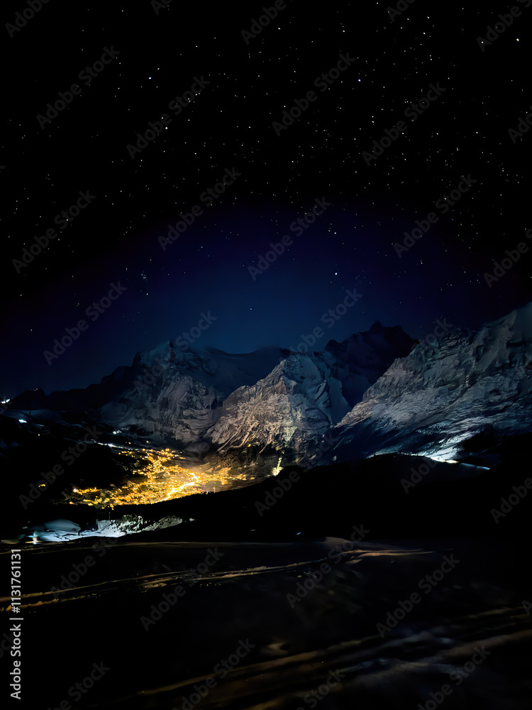 Panoramic view of illuminated Grindelwald at night seen from Maennlichen in winter against sky full of stars