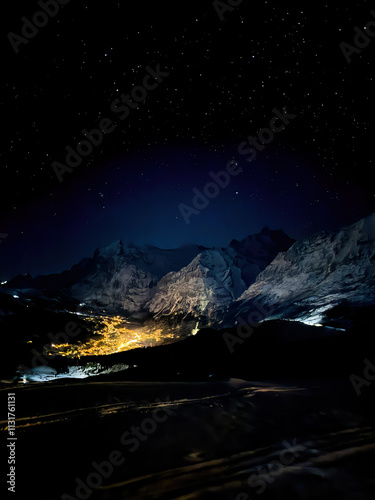 Obraz na płótnie Panoramic view of illuminated Grindelwald at night seen from Maennlichen in winter against sky full of stars w salonie